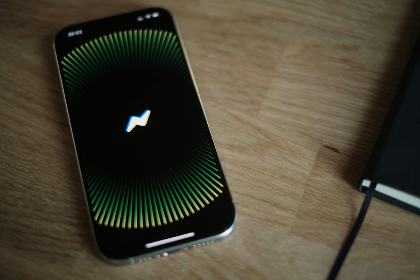 Smartphone con icona di un'app di messaggistica su un tavolo di legno.